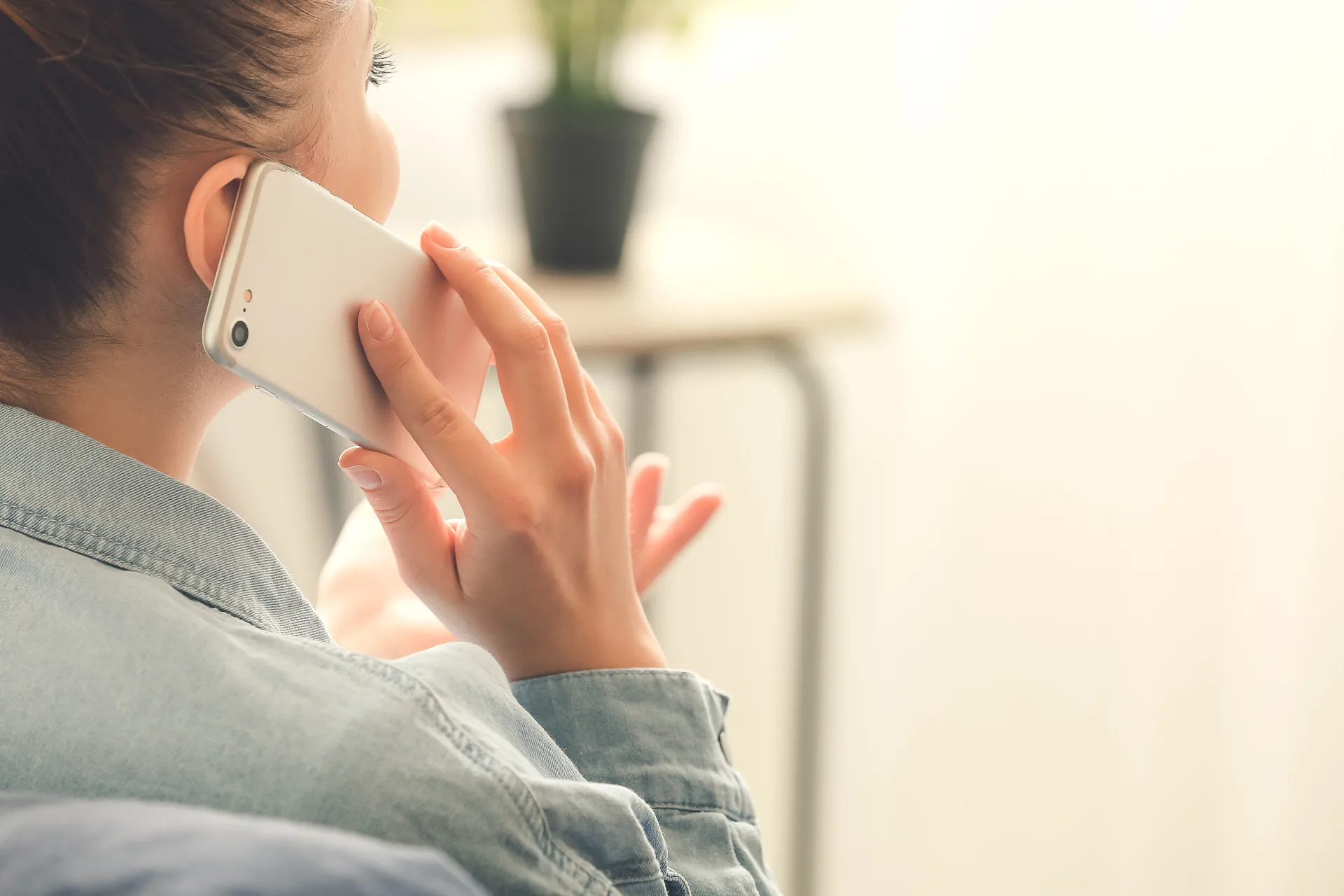 A woman talking on her mobile phone, facing away from the camera