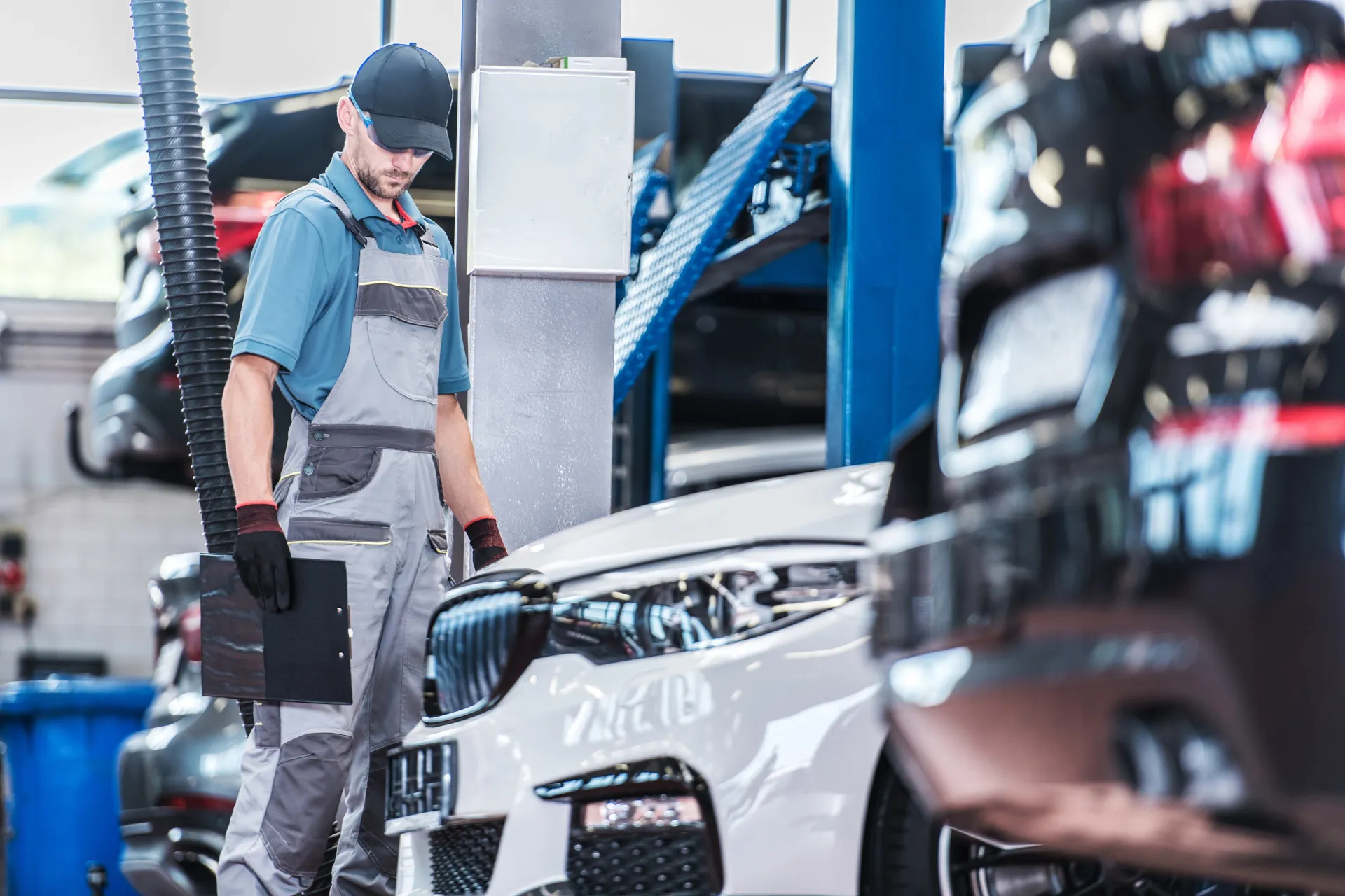 A mechanic with a clipboard looking at a BMW